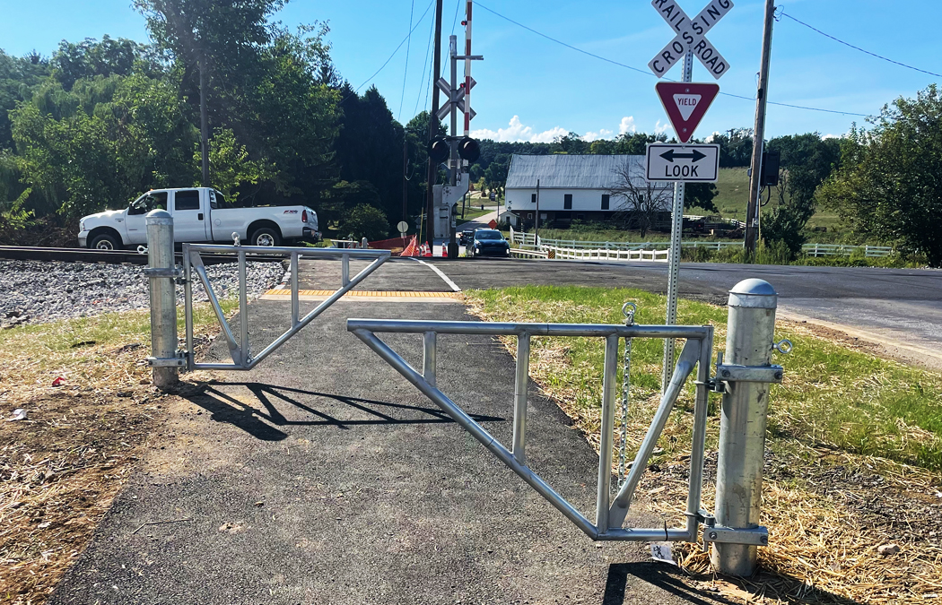 gates along a bike path at train tracks to slow down and protect riders