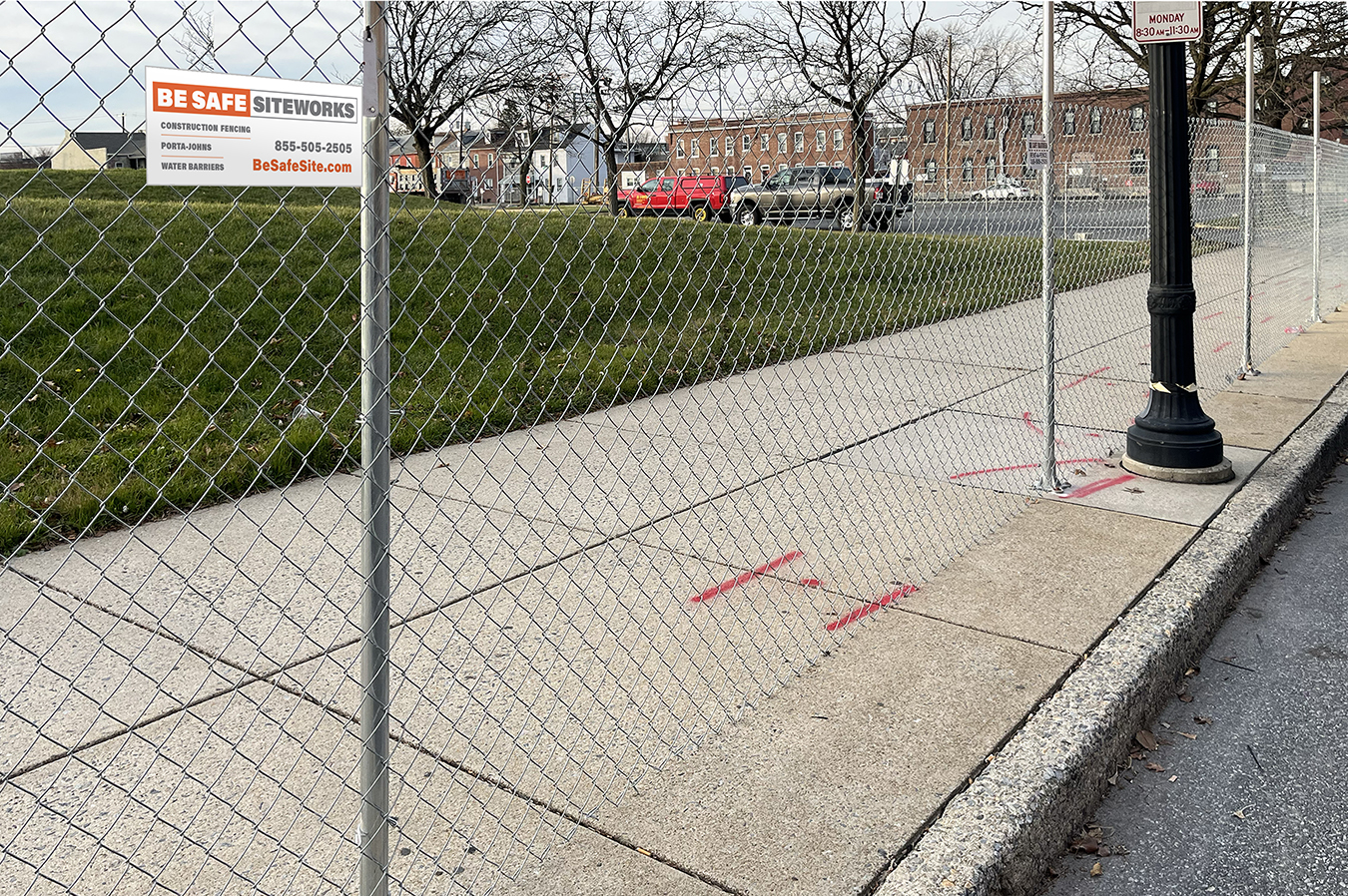 Driven fence posts bolted down on a sidewalk