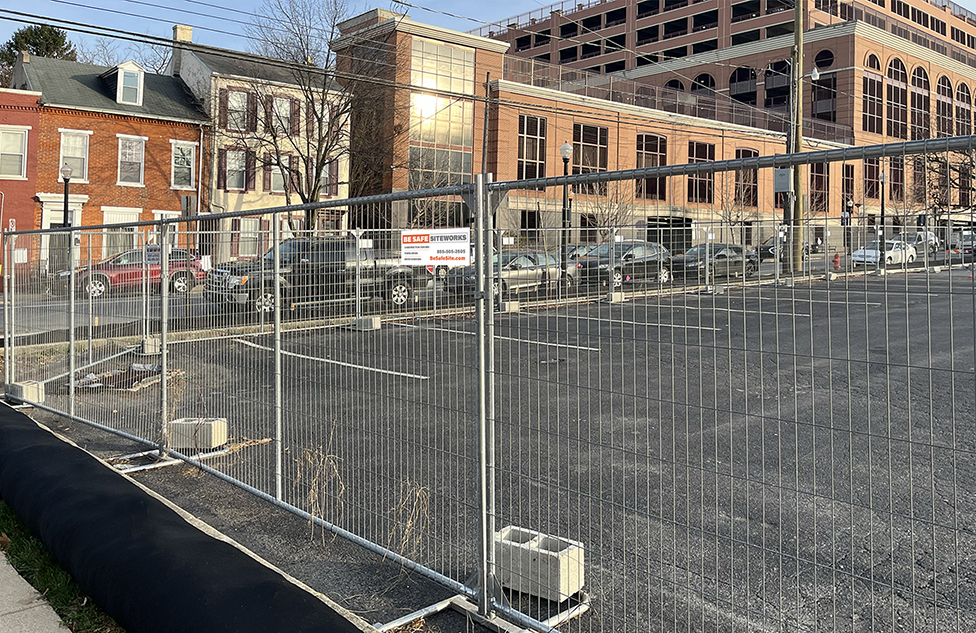 Panel fence with concrete blocks protecting parking lot
